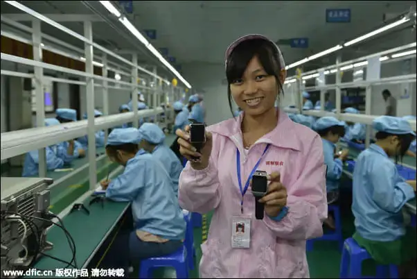 A woman worker holding smartwatches at a Chinese facility