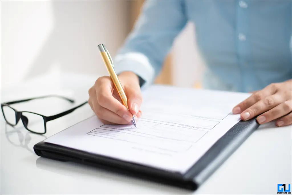 A person signing terms and conditions using a pen.