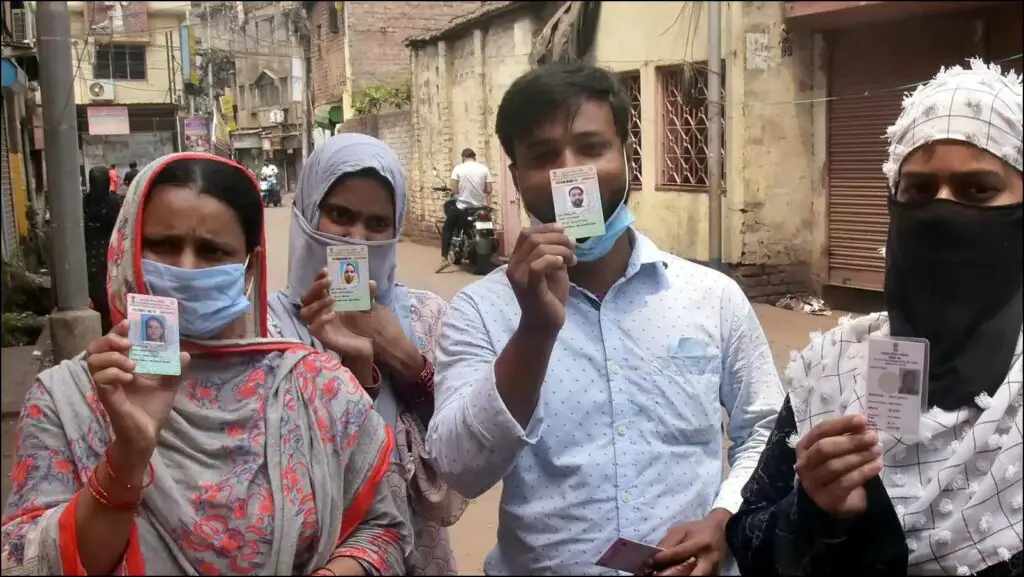 Four People showing their Voter ID card.