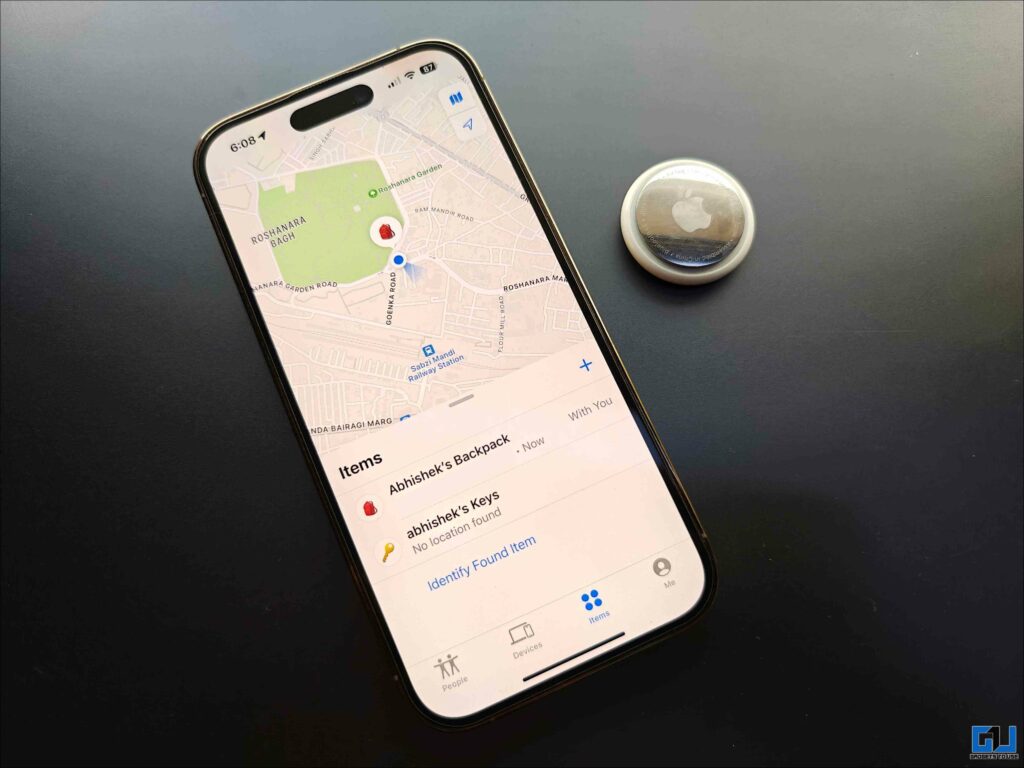 An AirTag placed next to the connected iPhone with the Find My app open.